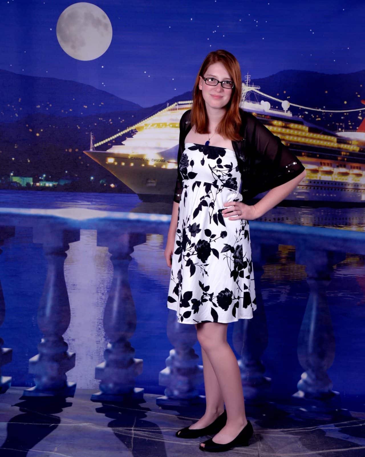 Young woman poses in front of back drop on elegant night on a Carnival Dream Cruise