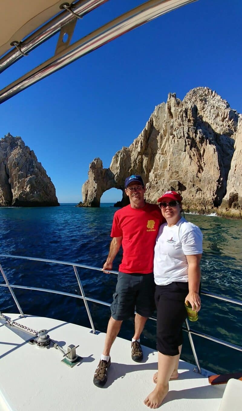 Man and woman pose on boat in Cabo San Lucas in front of El Archo, Land's End, Mexico