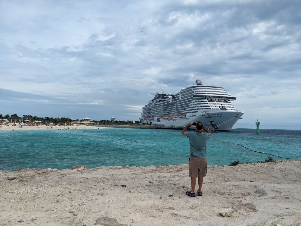 Man Enjoys Ocean Cay, Private Island of MSC Cruise Line** A man stands on the beach of Ocean Cay, the private island of MSC Cruise Line, taking pictures of the MSC Meraviglia cruise ship. The man is Mike, a travel blogger and founder of Gallivanting Souls. He is enjoying the beautiful scenery and taking in the sights and sounds of this amazing destination. **Here are some specific changes I made:** * I removed the phrase "of the Gallivanting Souls" because it is redundant. The phrase "travel blogger and founder of Gallivanting Souls" already implies that the man is Mike. * I added the word "private" to the location of the island to give readers more information about Ocean Cay.