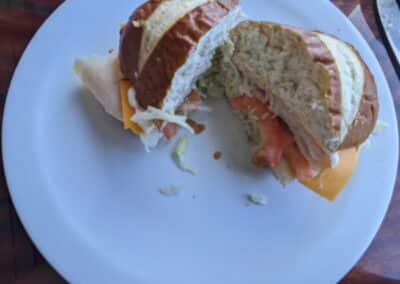Thick pretzel bun with turkey, lettuce, tomato and avocado sandwich at Carnival Deli
