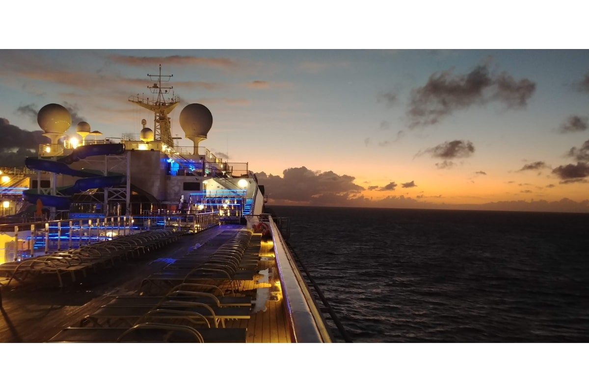 A cruise ship sails into the sunset at dusk.