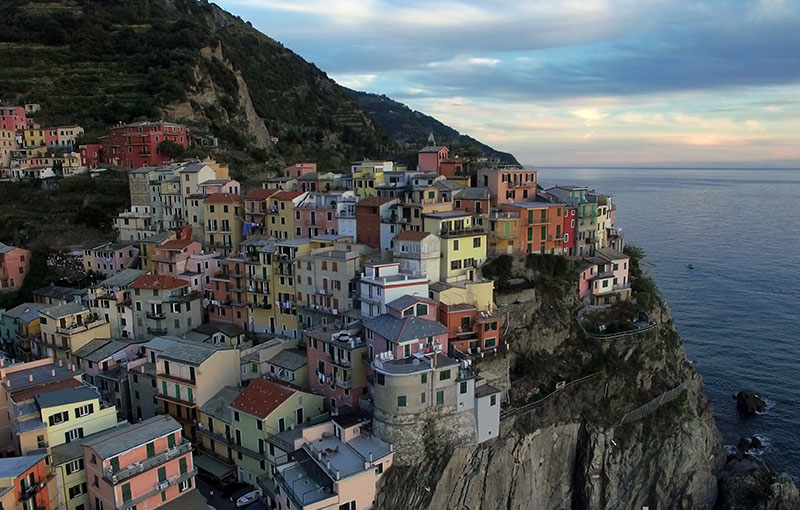 colorful houses sit atop a cliff overlooking the ocean