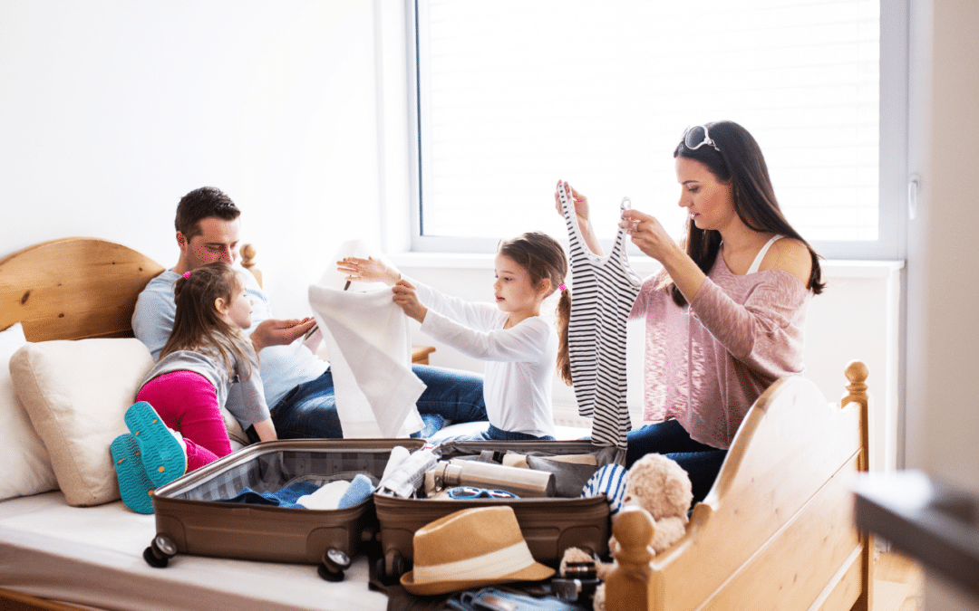 Family sitting on bed packing luggage without packing cubes