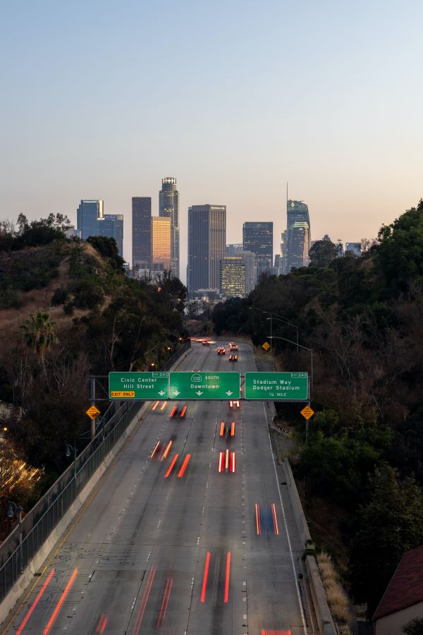 Los Angeles skyline and freeway at dusk.