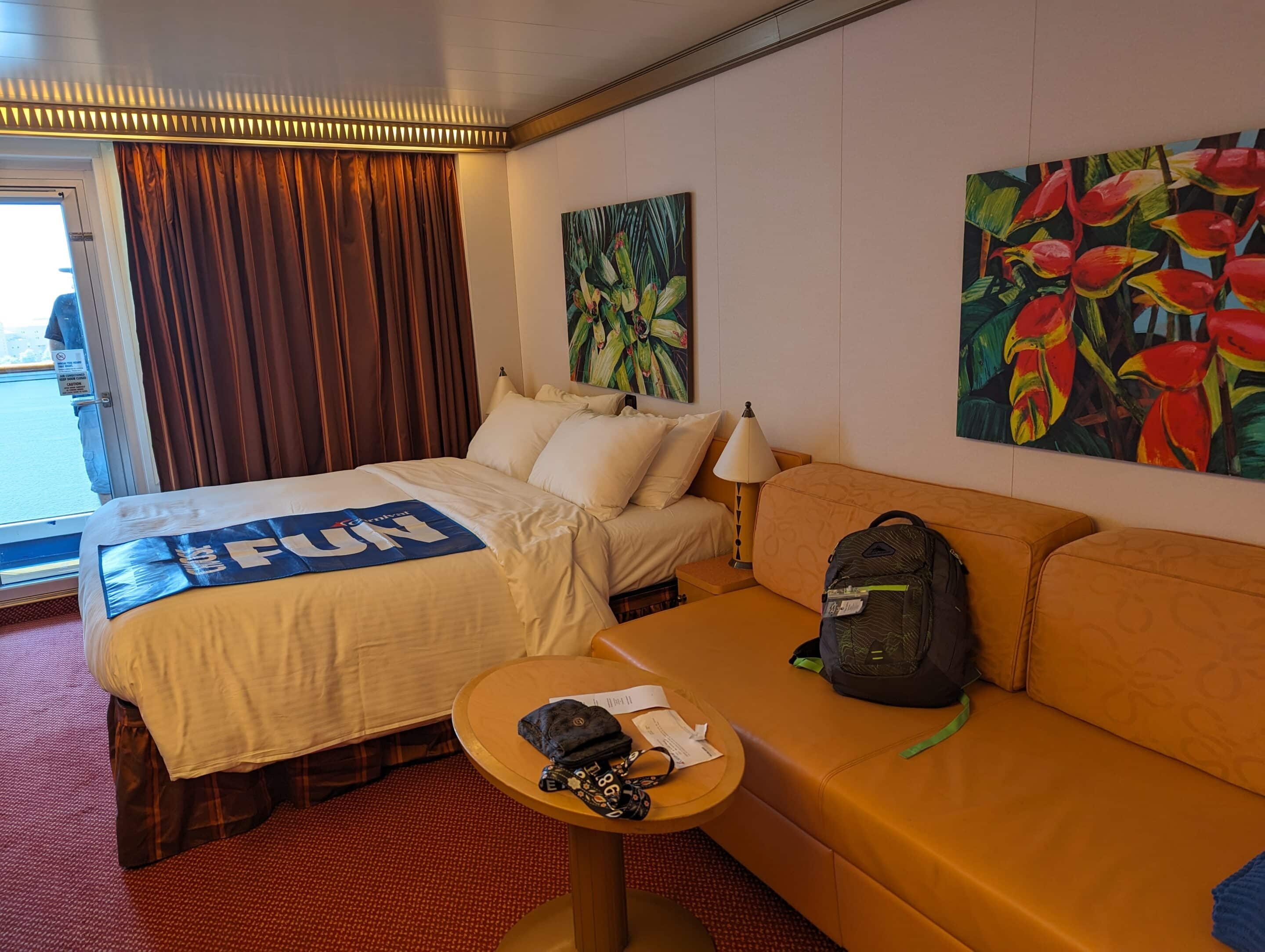 A Carnival Cruise balcony stateroom on Carnival magic shows bed, couch, and the large balcony window room 8435. Even in your stateroom you should be thinking of your cruise safety.