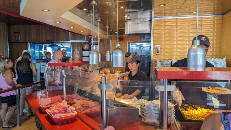 Lots of hungry guests wait in line at Guys Burgers on Carnival Magic