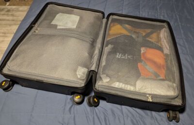 Level8 Luminous check-in 24 inch case opened on bed to show duel zipped sides