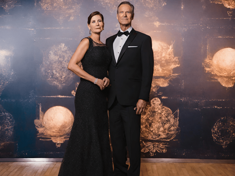 man and woman dressed to impress on elegant night pose at a backdrop