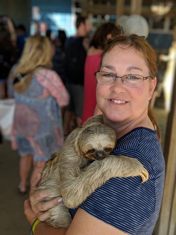 Empty nest cruise expert, Kristina holds a sloth in Roatan, Honduras.