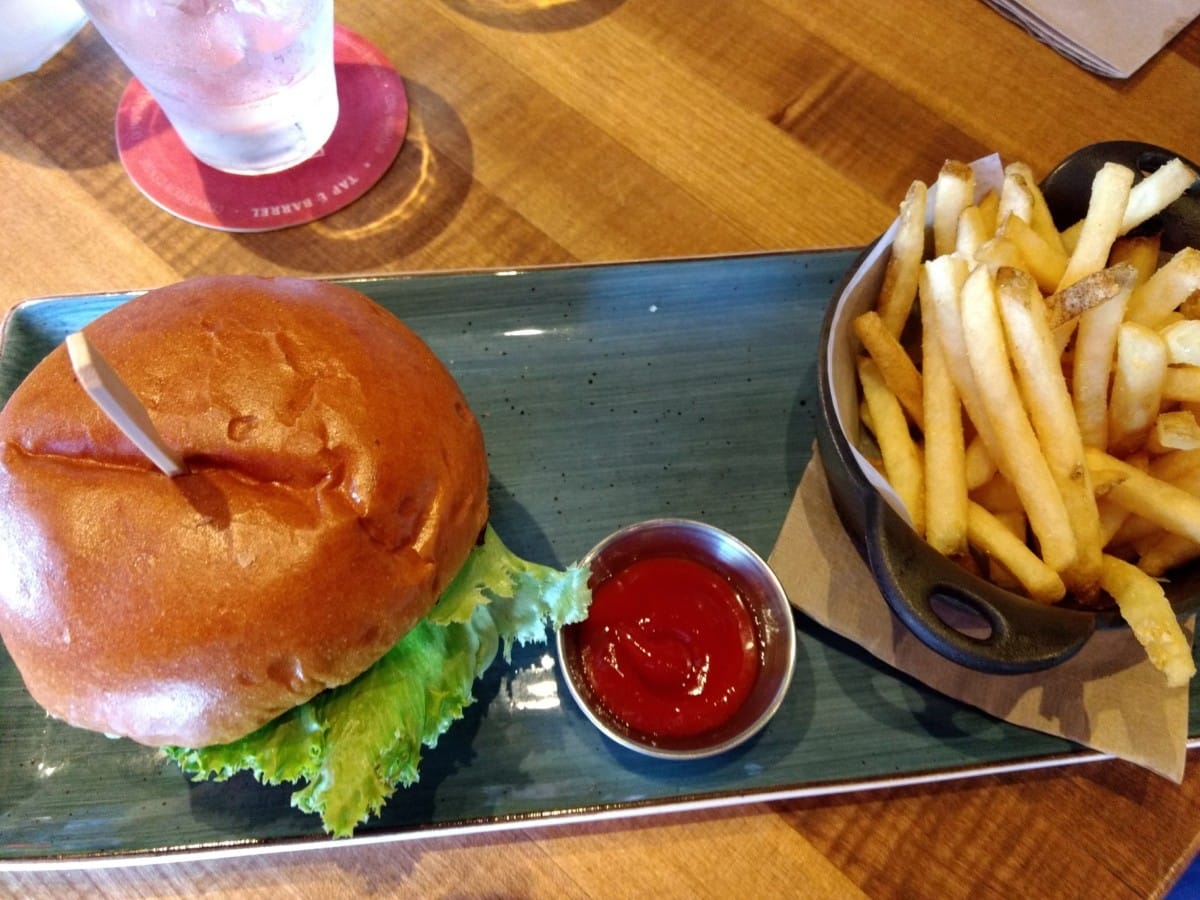 Tuna burger at Tap and Barrel Olympic Village, Vancouver, BC with fries and home made catsup on a platter.