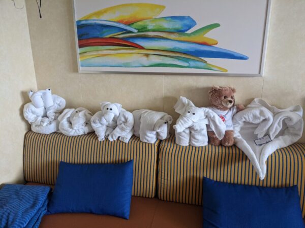 A weeks worth of towel animals sit on the back of a sofa with a Teddy bear from Groove for St Jude on Canivval Panorama