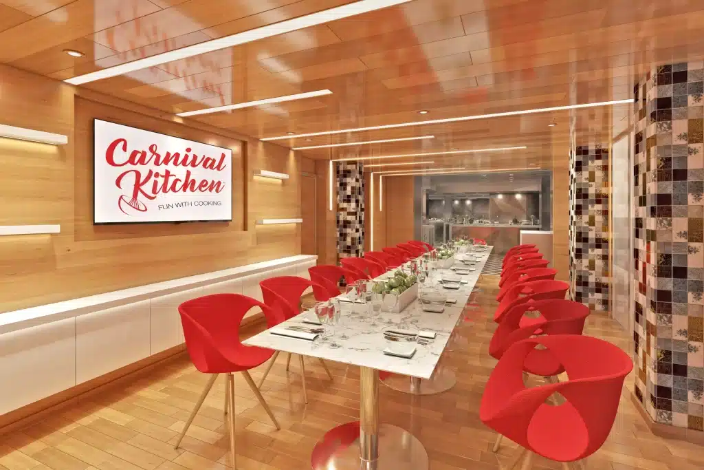 white dining table flanked by red retro dining chairs in the Carnival Kitchen