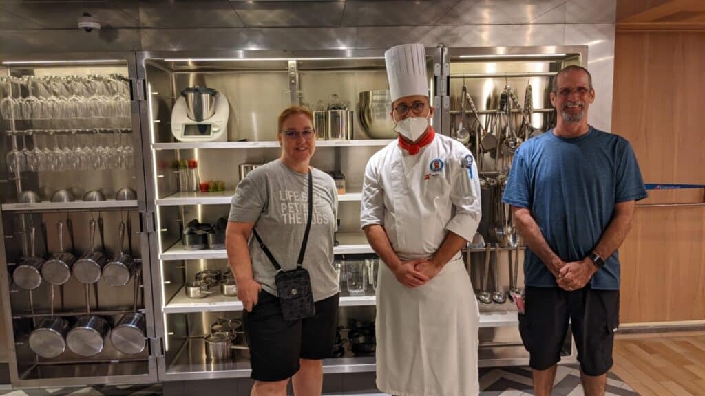 man and woman pose with cooking insturctor at Carnival Kitchen on Carnival Panorama